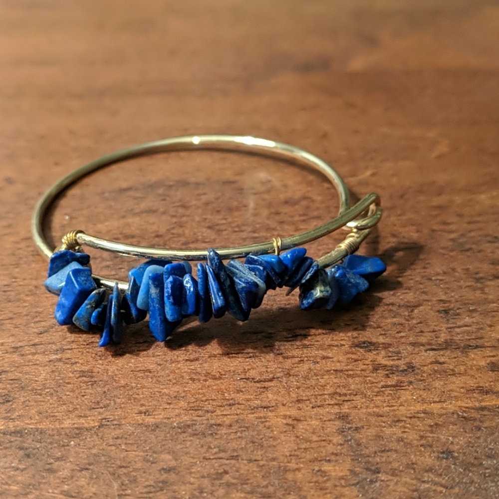 Gold cuff bracelet with blue stones